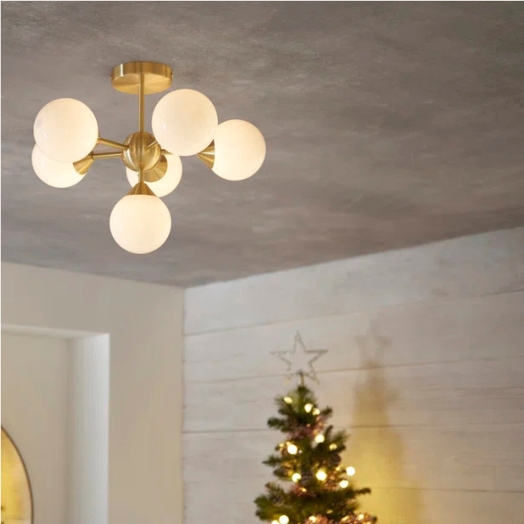 Modern ceiling light fixture with glass shades in a room with a Christmas tree.