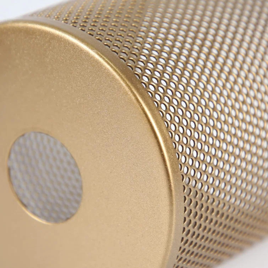Close-up of a gold cylindrical object with a perforated mesh design.