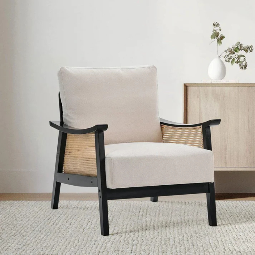 black indoor rattan armchair with curved open weave design, in a modern living room.