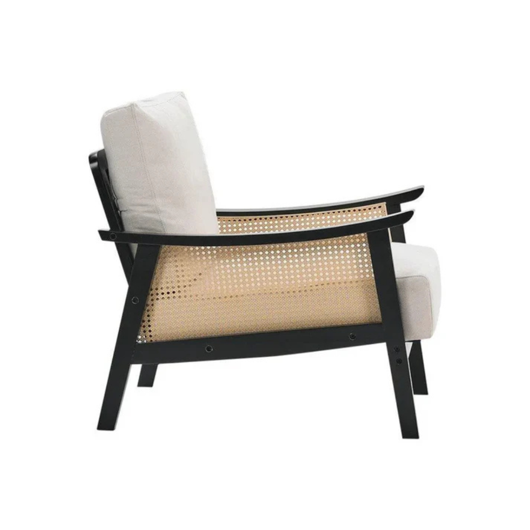 black indoor rattan armchair with curved open weave design, white background, side view.