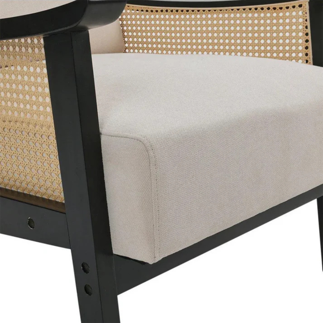 black indoor rattan armchair with curved open weave design, close up to upholstery and rattan design.