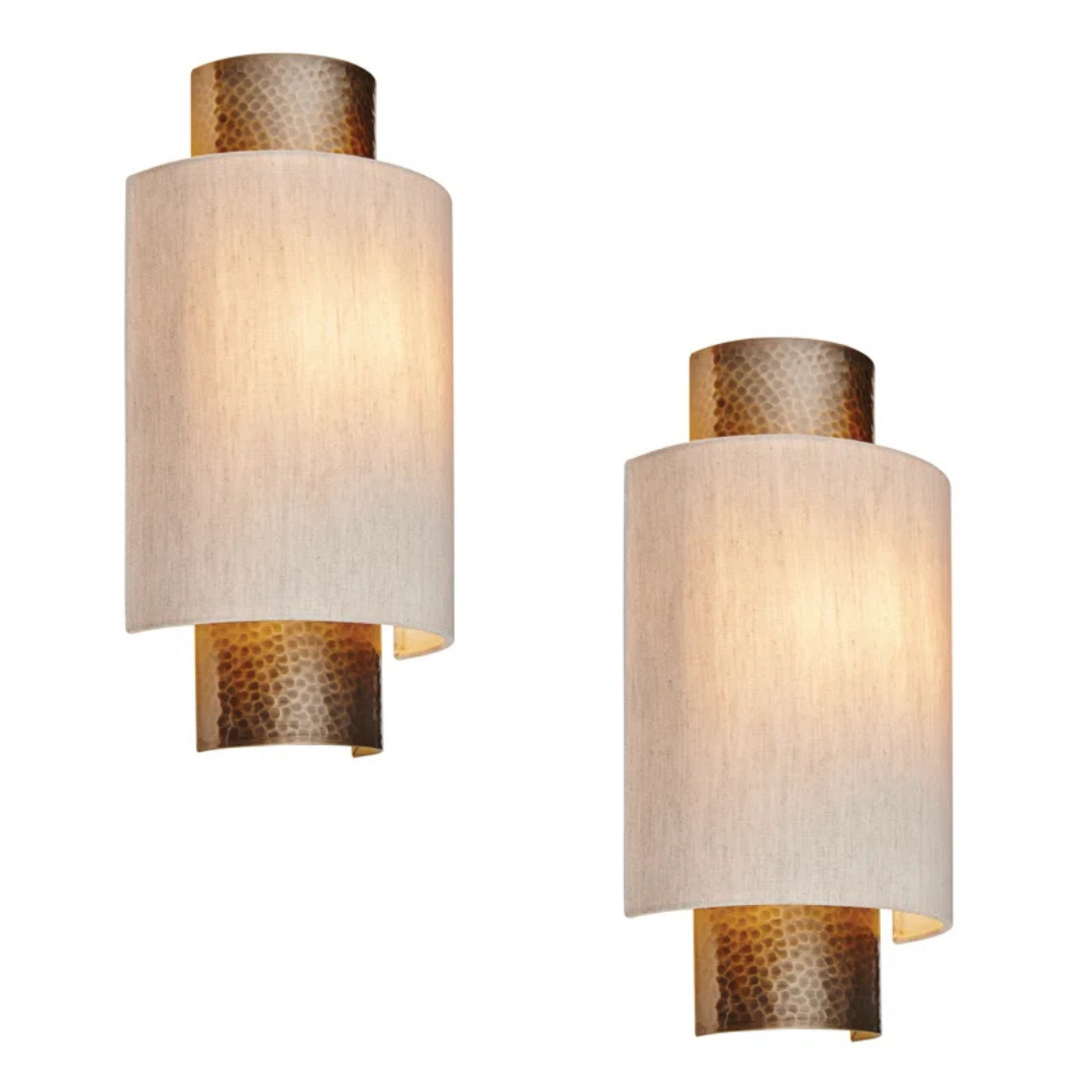 Two wall sconces with textured beige shades and gold accents on a white background
