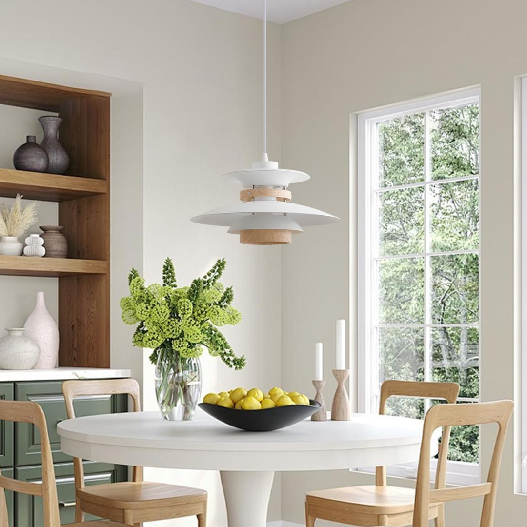 Modern dining room with a white table, wooden chairs, and a vase of green flowers.