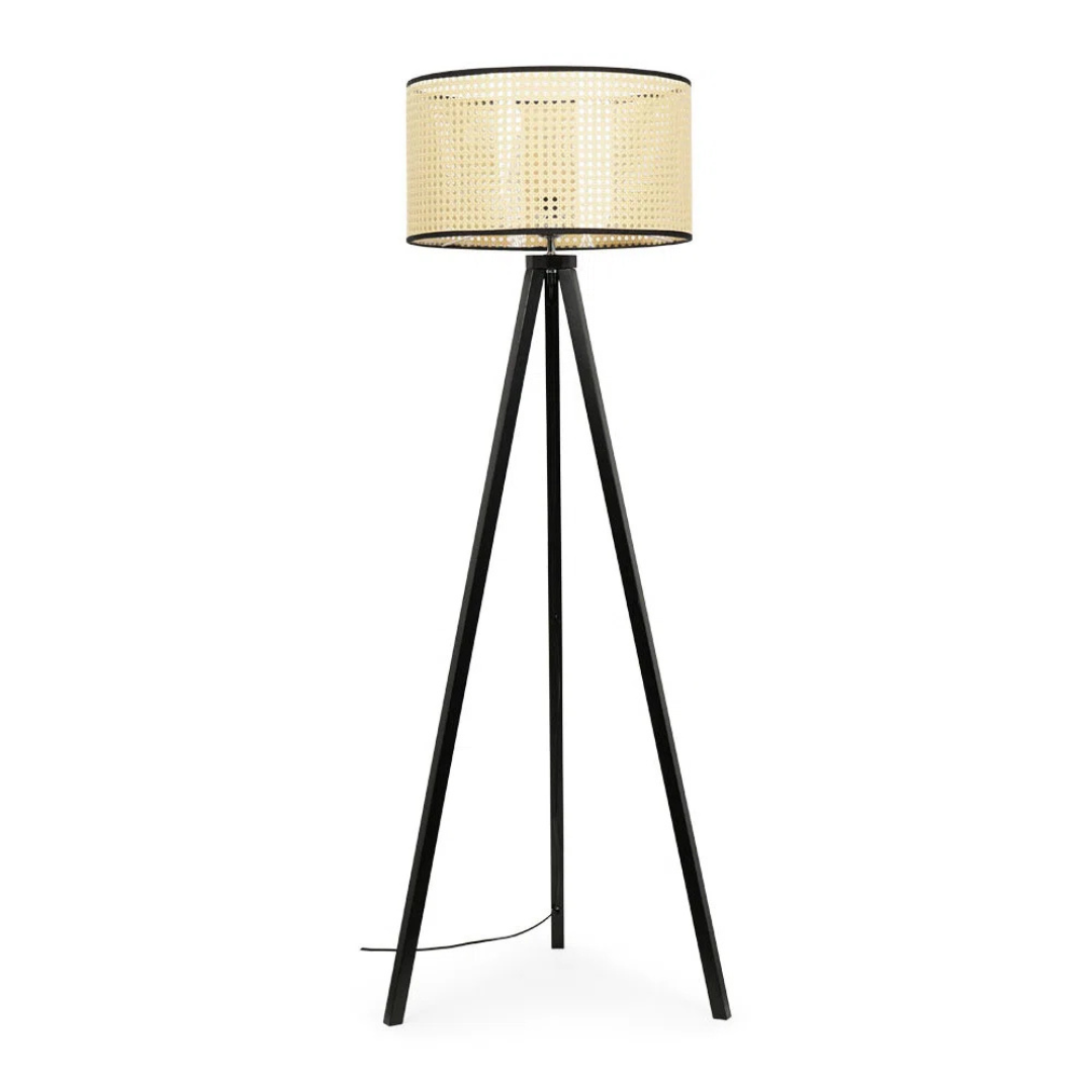 Black tripod floor lamp with a woven shade on a white background