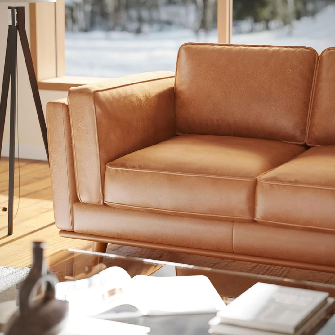 Brown leather sofa in a room with a snowy outdoor view.