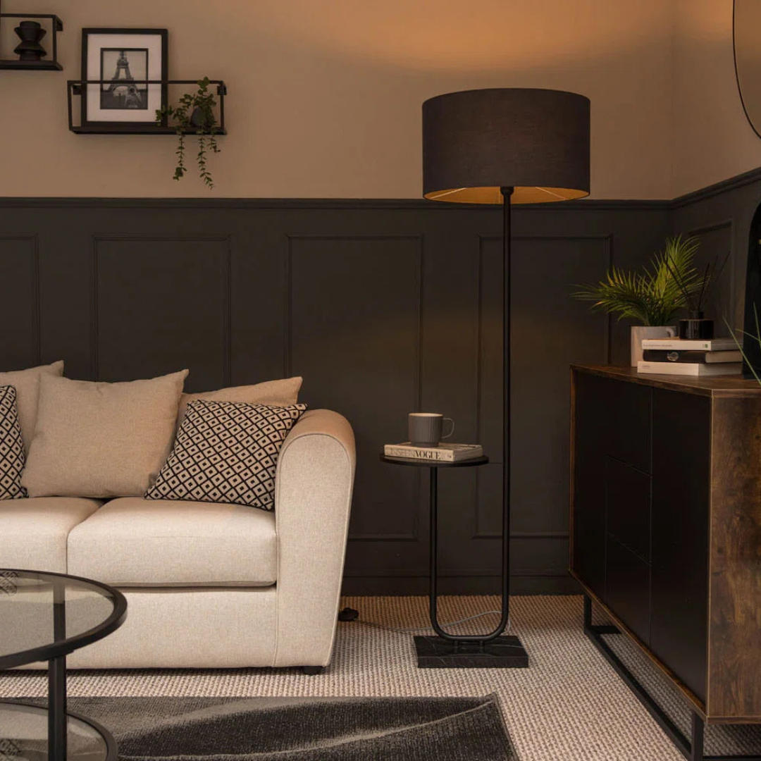 Modern living room with a beige sofa, side table, and decorative items.