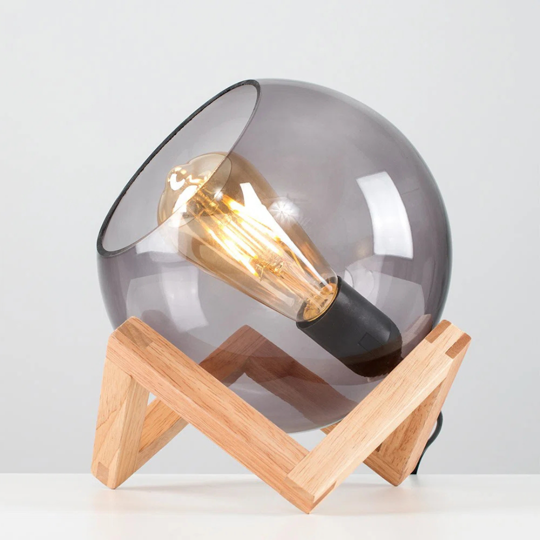 Modern table lamp with smoked glass shade and wooden base on a light gray background