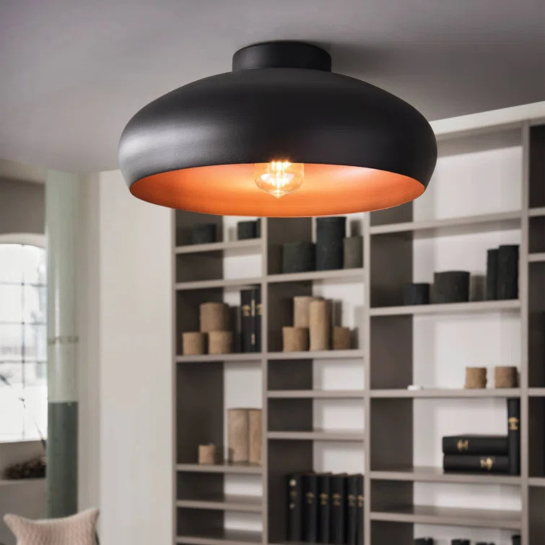 Black ceiling light fixture with orange interior in a room with shelves.