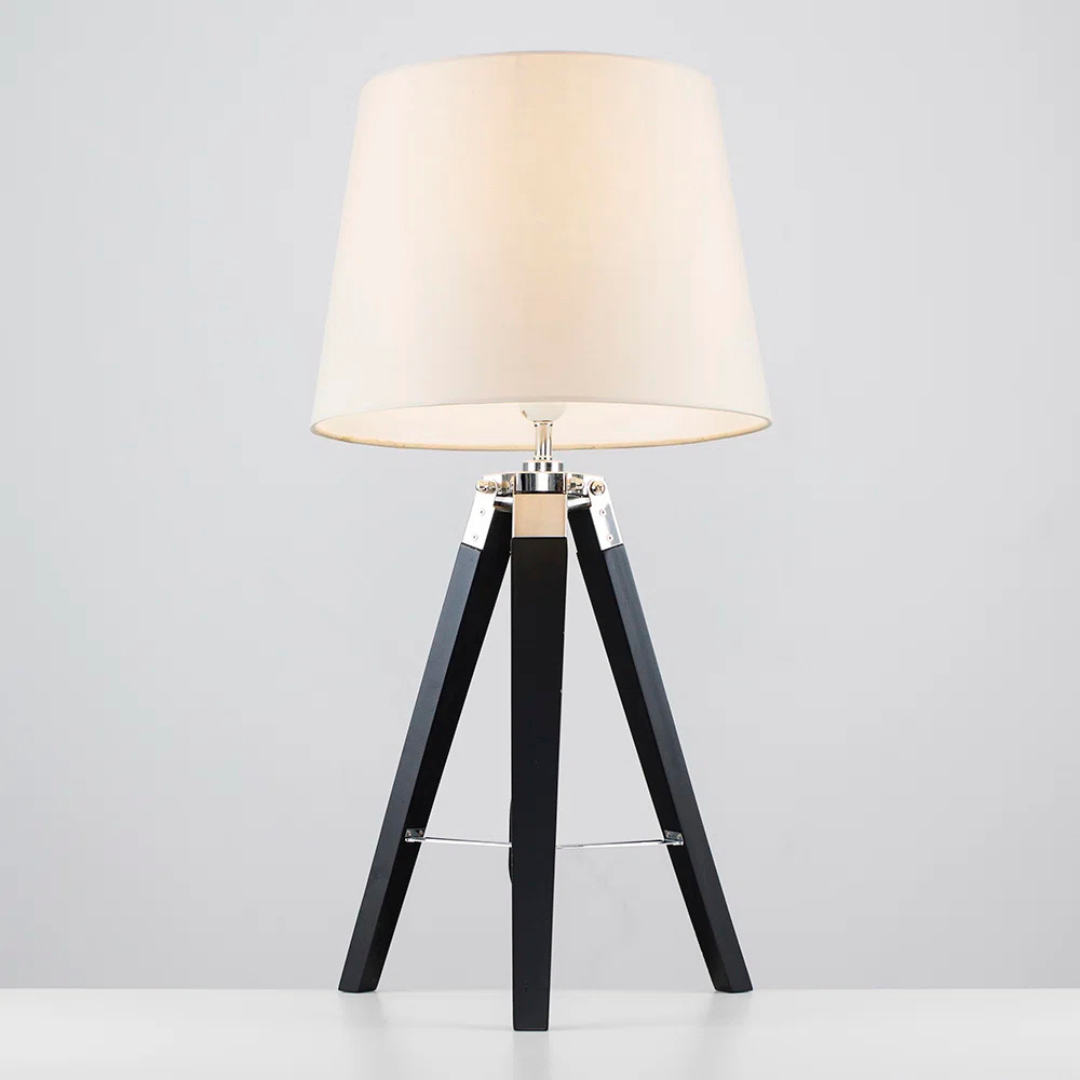 Table lamp with a white shade and black wooden base on a light gray background