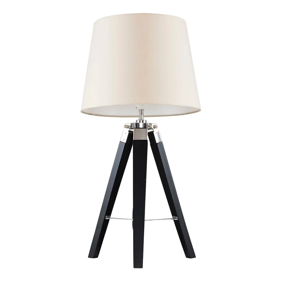 Table lamp with a white shade and black tripod base on a white background