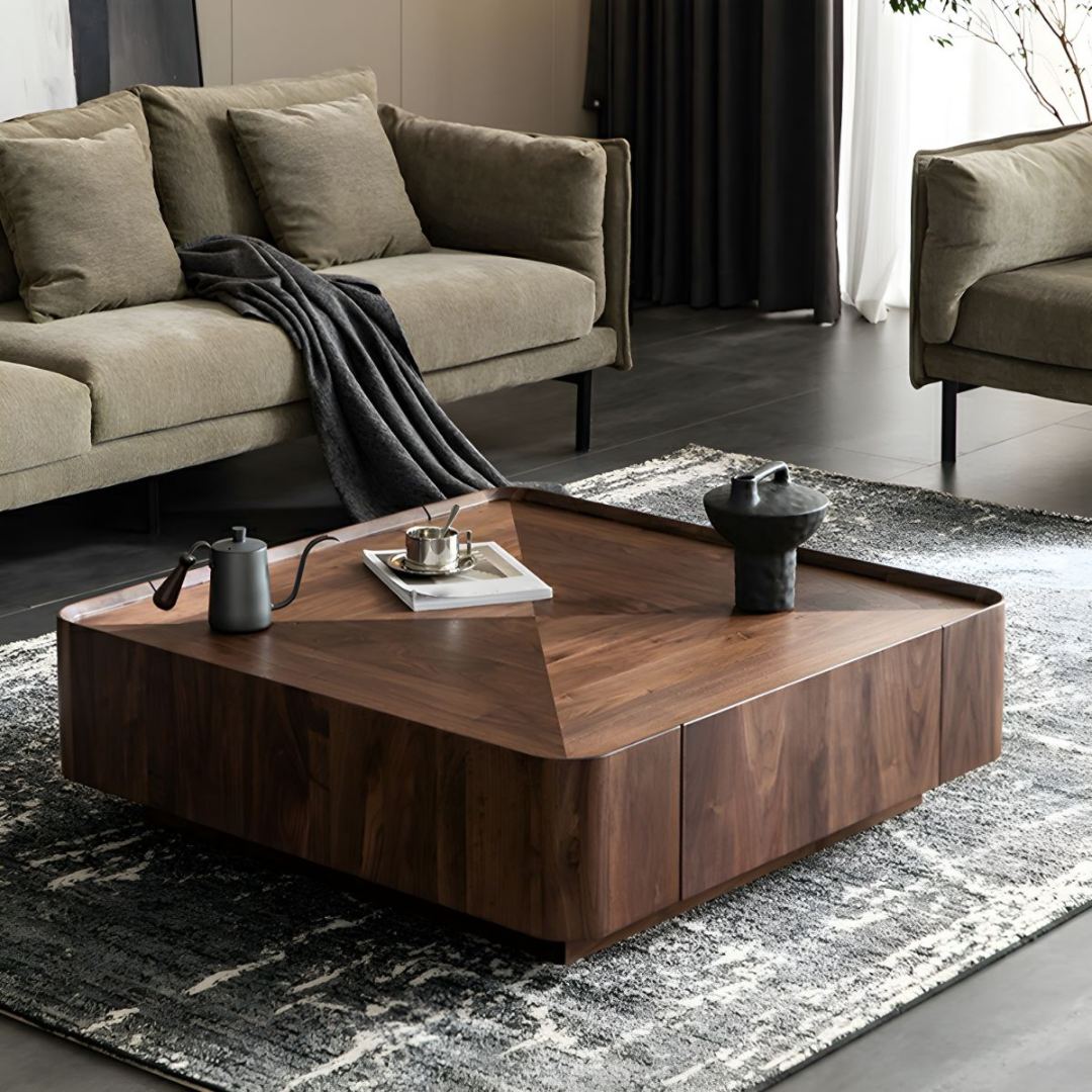 Modern walnut square coffee table with sculpted top in a living room setting, high angle view.