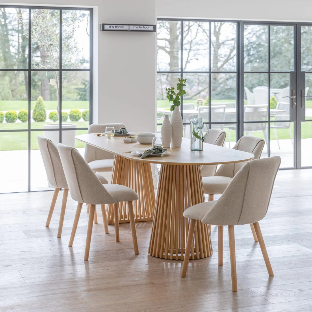 Oak Scandinavian Style Dining Room Table, set with 6 dining chairs, in a model home.