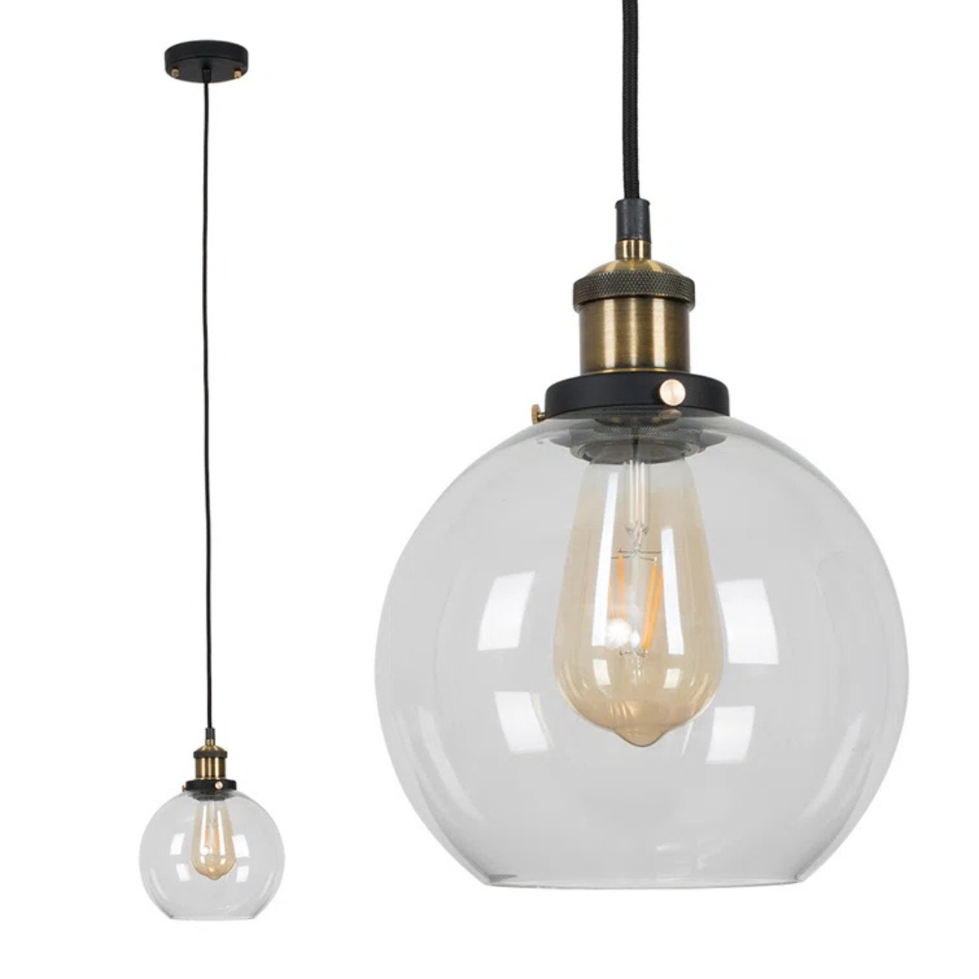 Clear glass pendant light with brass fixture on a white background