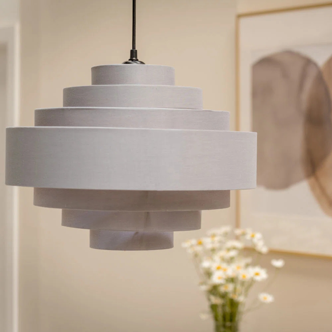 Gray pendant lamp hanging in a room with a blurred background