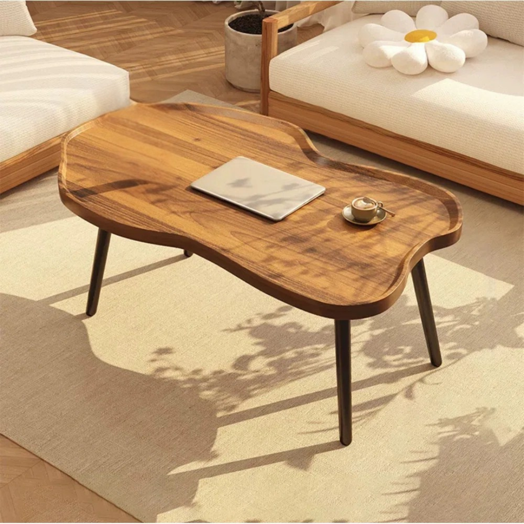Solid wood cloud coffee table with curved edges, set in a modern home.
