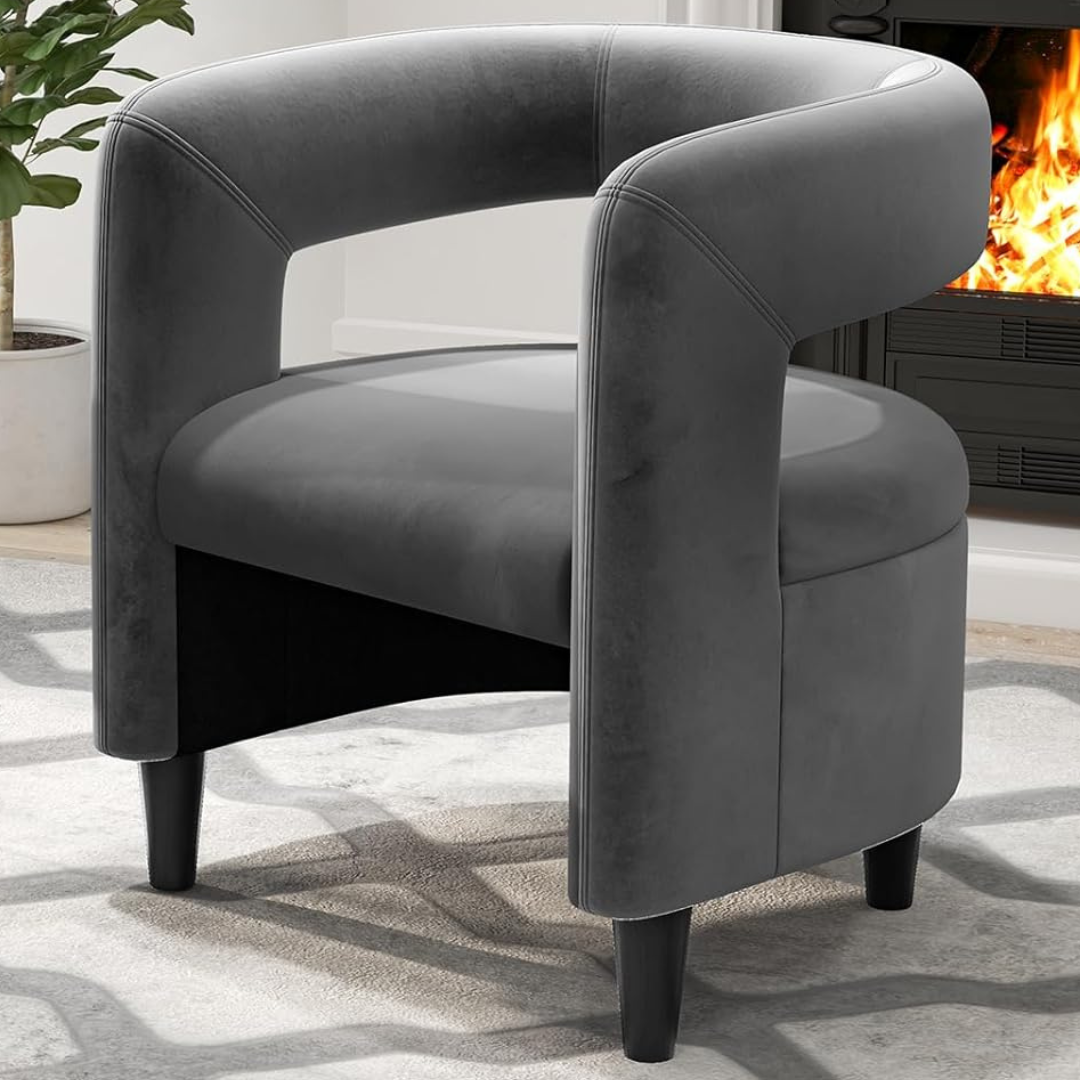 velvet grey accent chair and footstool set with rounded frame, set Infront of a fire place in a modern living room.