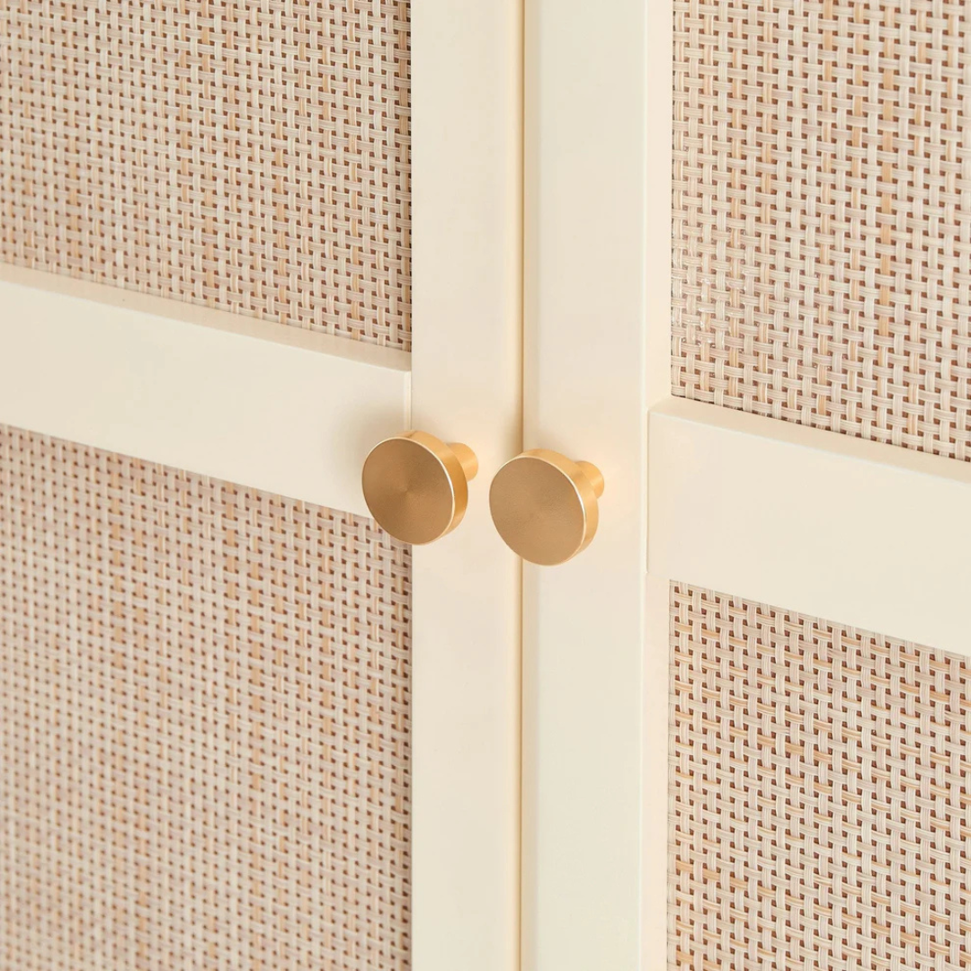 Close-up of a cabinet with woven texture and gold handles
