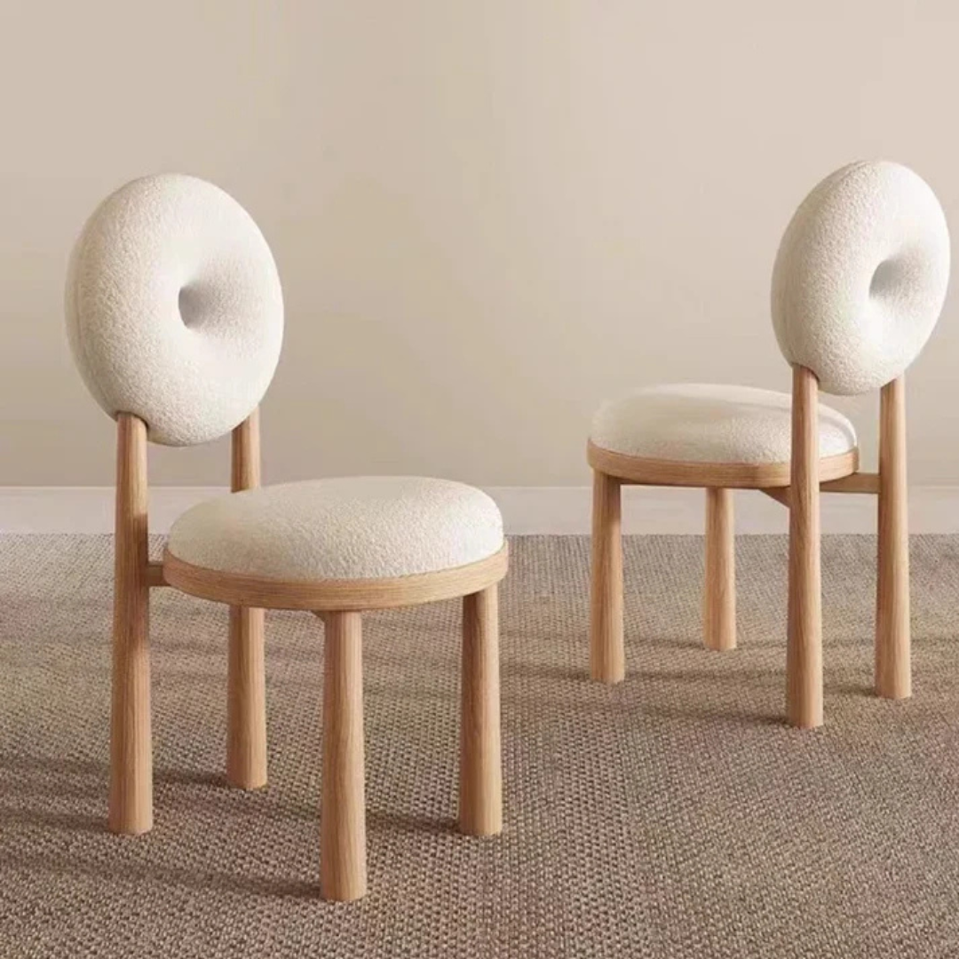 white boucle dining chair with curved back and soft seat, angled view in a home setting.