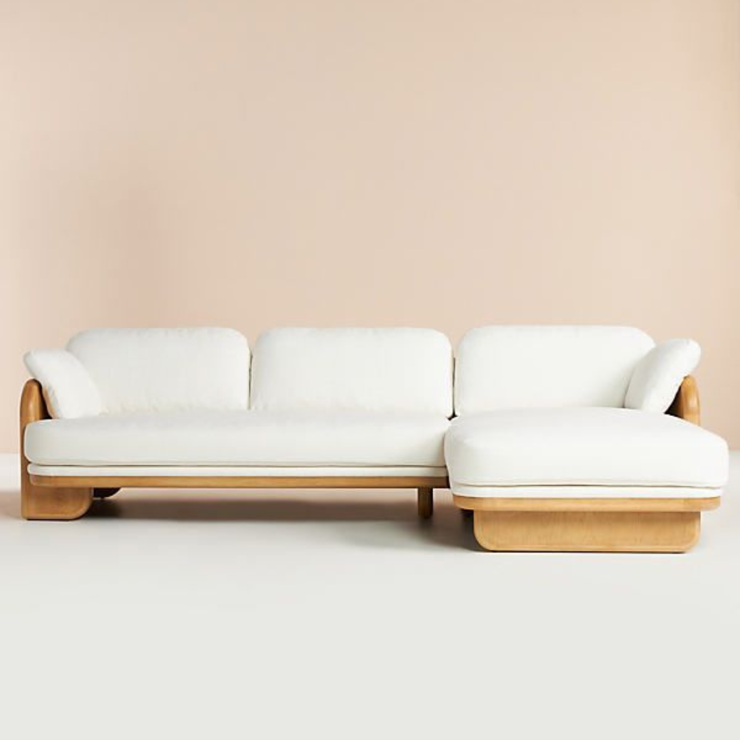 image shows a retro corner sofa set in a studio background with light pink walls.