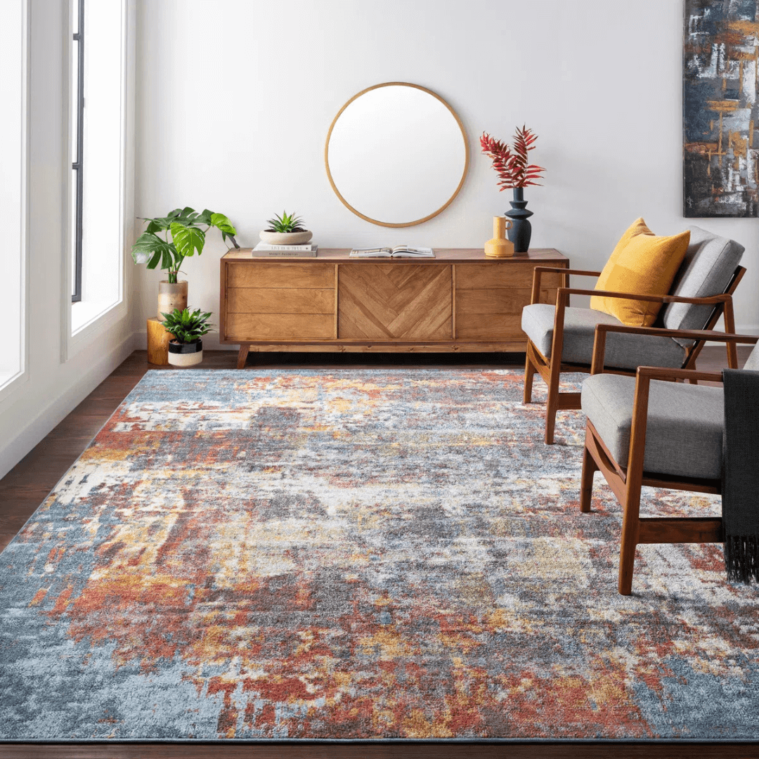 Living room with a colorful patterned rug, wooden sideboard, and gray chairs.