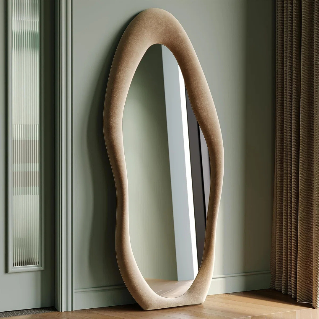 Beige oval mirror leaning against a green wall.