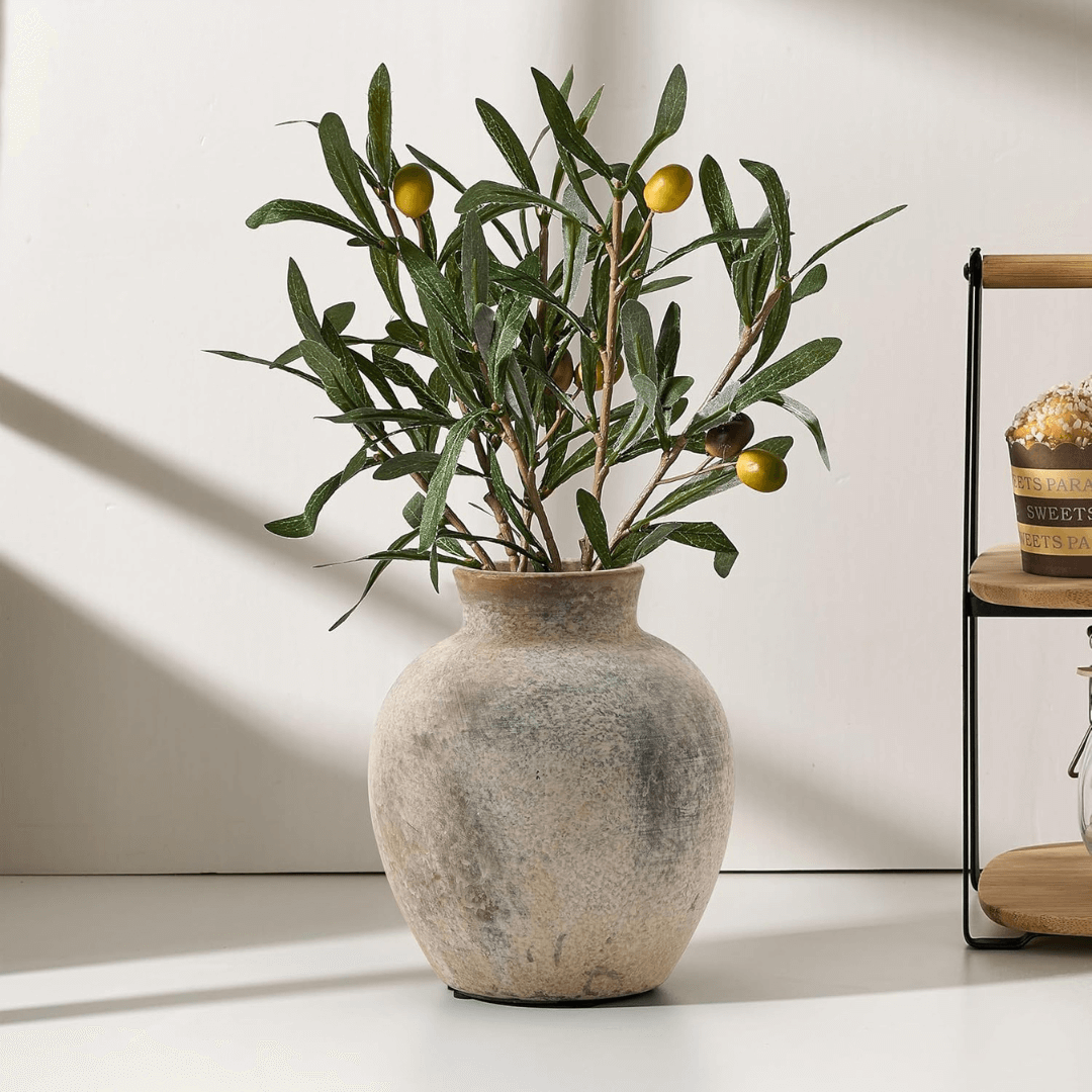 Decorative vase with olive branches on a light surface