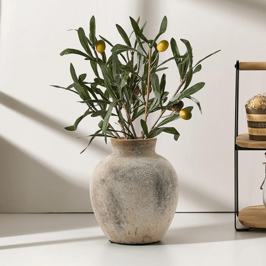 Decorative vase with olive branches on a light surface