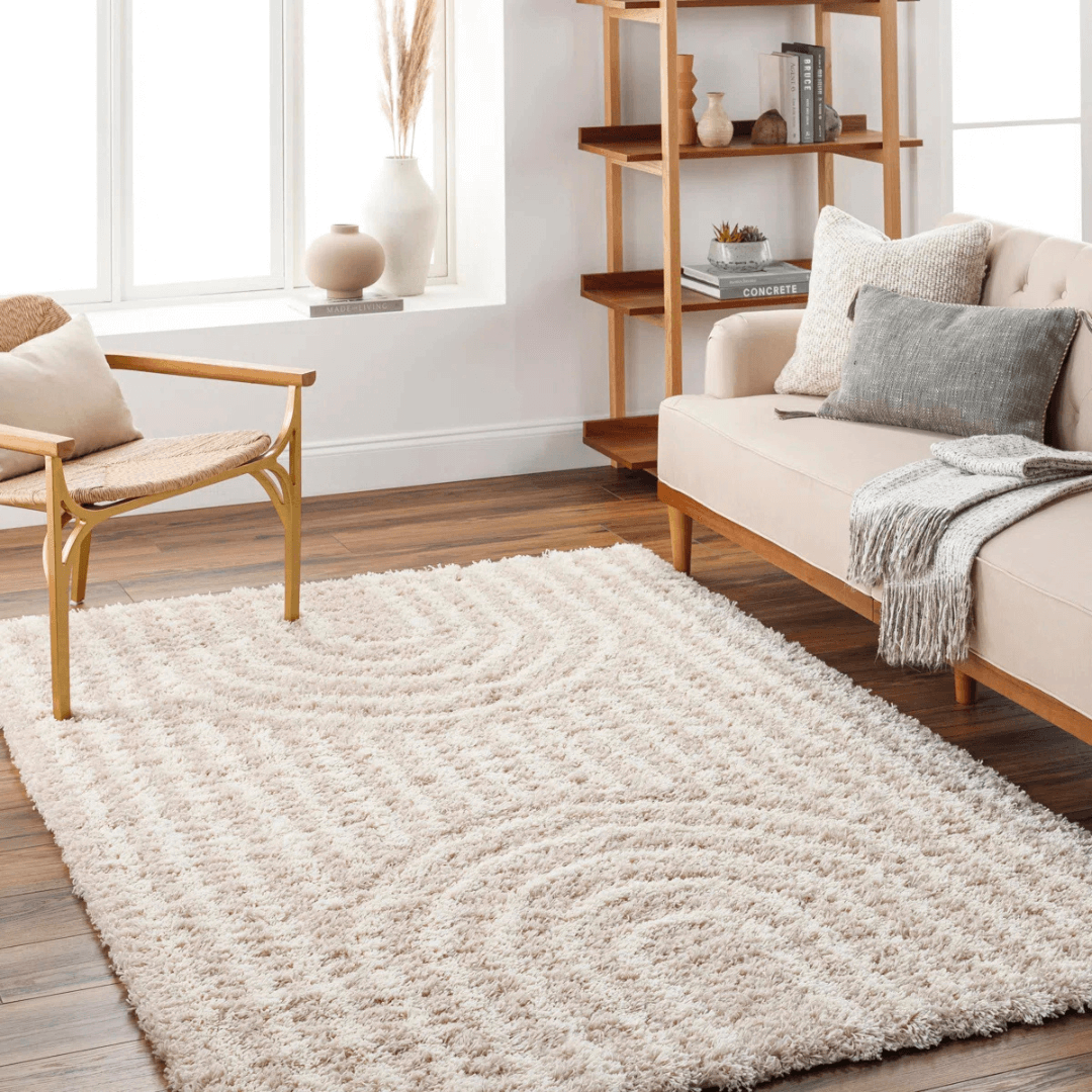 Living room with a beige rug, sofa, and armchair.