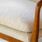 Close-up of a textured beige cushion with wooden armrests