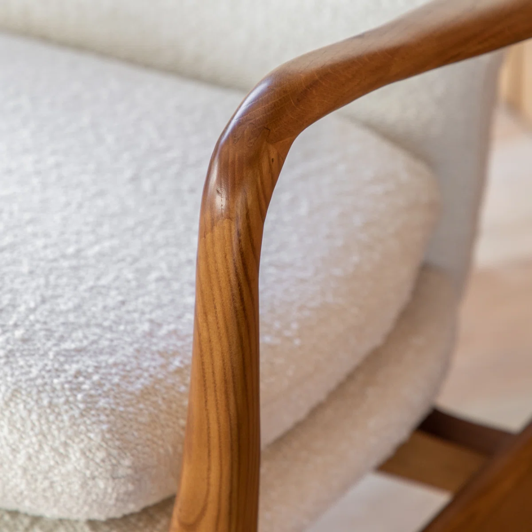 Close-up of a wooden armrest on a white textured surface