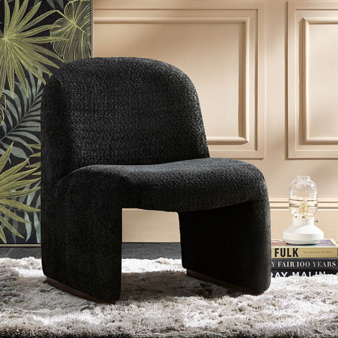 black boucle funky accent chair with curved design, in a modern reading room.
