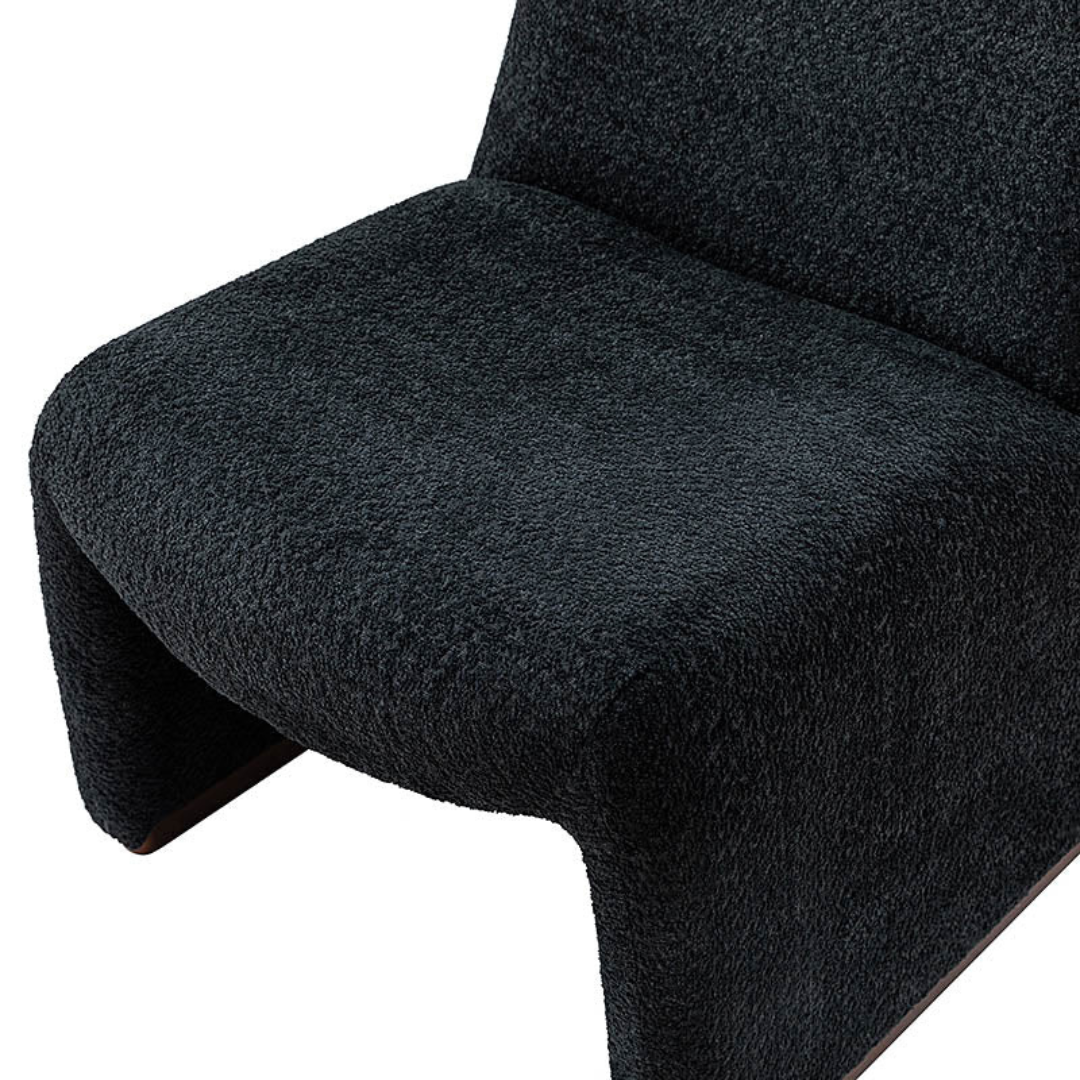 black boucle funky accent chair with curved design, close up to upholstered seat.