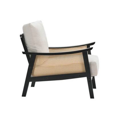 black indoor rattan armchair with curved open weave design, white background, side view.
