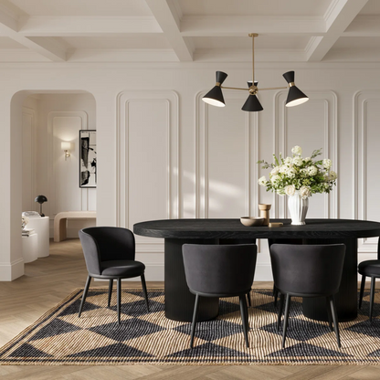 Modern dining room with black table and chairs, featuring a chandelier and decorative elements.