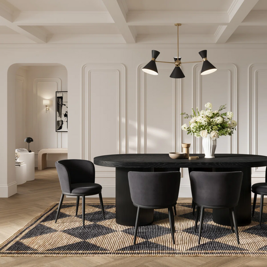 Modern dining room with black table and chairs, featuring a chandelier and decorative elements.