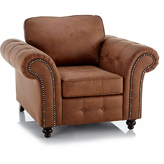 Brown leather armchair with tufted backrest and nailhead trim on a white background