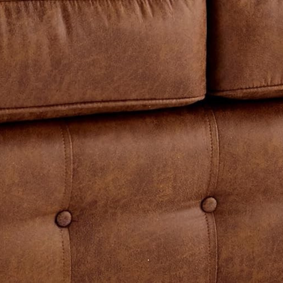 Close-up of a brown leather sofa with button details