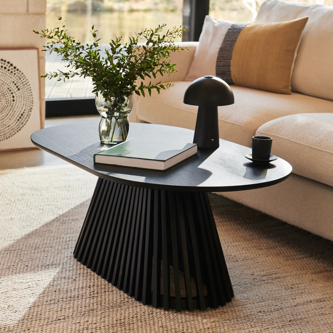 Ciera Oval Wood Coffee Table-Black, side view in a modern living room.
