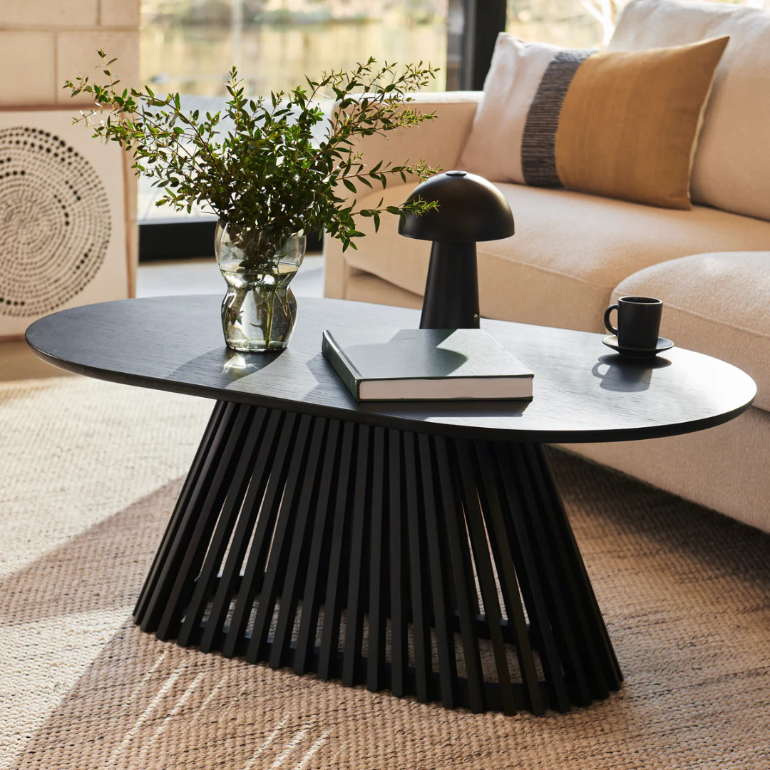 Ciera Oval Wood Coffee Table-Black, angled view, in a modern living room.