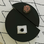Contemporary low round coffee table with magazine slot, black table, top view.