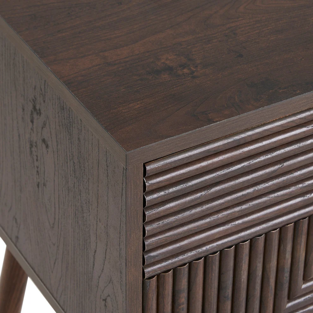 Close-up of a wooden side table with a textured surface and geometric design. close up