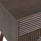 Close-up of a wooden side table with a textured surface and geometric design. close up