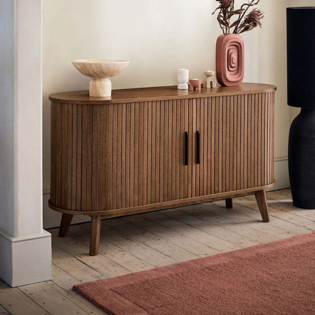 Wooden sideboard with decorative items in a room setting