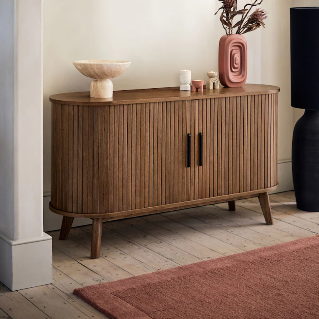 Wooden sideboard with decorative items in a room setting