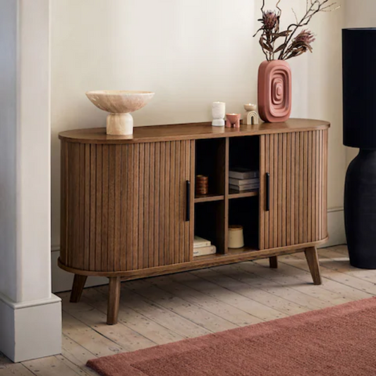 Wooden sideboard with decorative items in a room setting