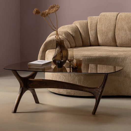 Beige sofa with a glass coffee table in a living room setting
