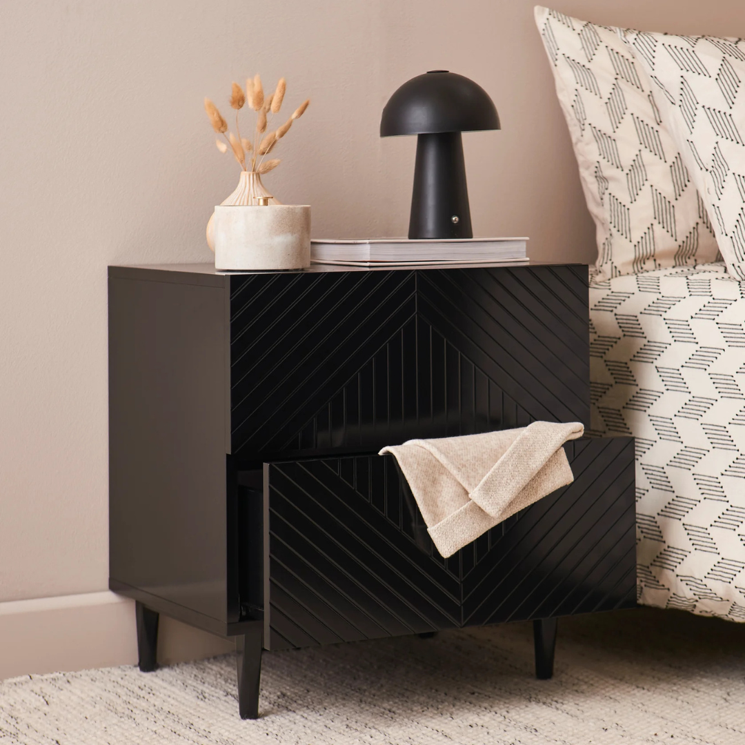 Geometric Bedside Cabinet Black, set in a model home, angled view, with draw open.