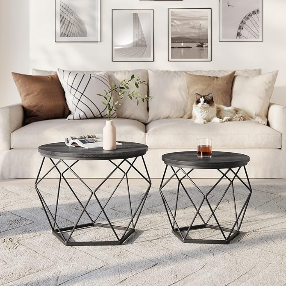 Geometric coffee table set with sculptural metal bases, black tops set in a modern living room, front view.