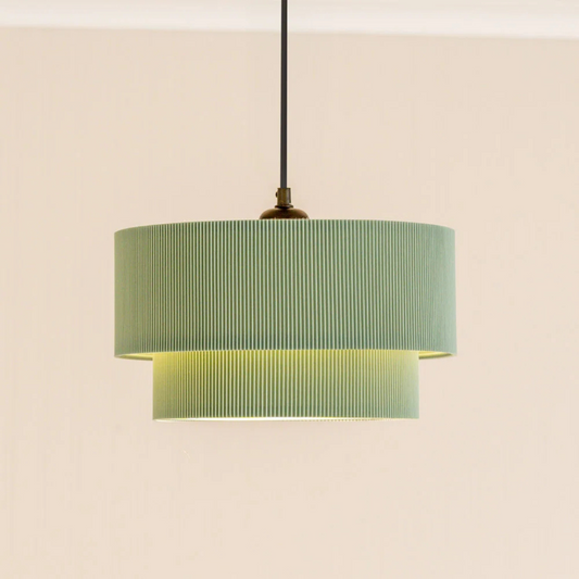 Green pendant lamp with striped shade on a beige background