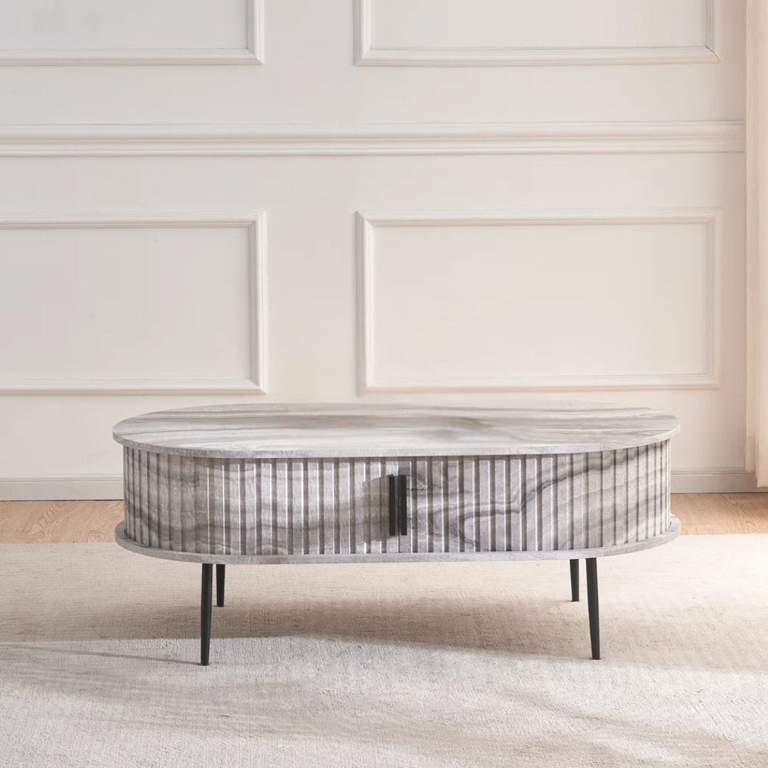 Grey marble effect oval coffee table with fluted base, in a modern home with the doors closed.